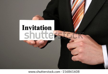 human hand holding a business card with a message invitation
