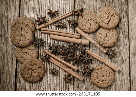 Cinnamon sticks, star anise and gingersnap cookies on rustic wood background