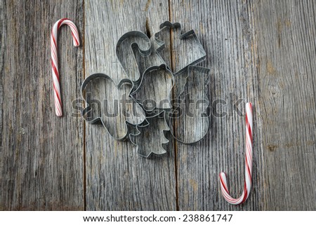 Holiday Cookie Cutters and Candy Cane on Rustic Wood Background