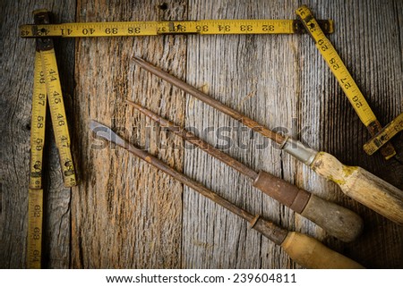 Measuring Tape and Screwdriver on Rustic Old Wood Background