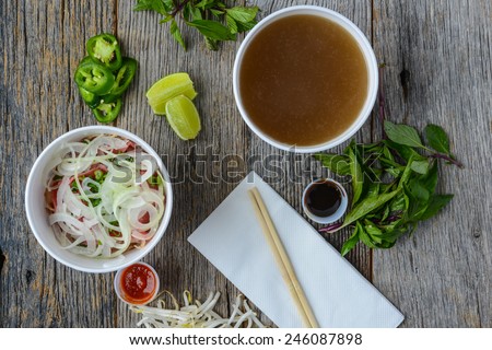 Pho Fast Food To Go on Wood Background with Peppers and Basil