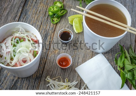 Pho Fast Food To Go on Wood Background with Peppers and Basil