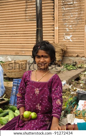 BANGALORE, INDIA - JUNE 26: An unidentified vendor girl sells fruit on an unnamed street in Bangalore, India on June 26, 2011. About 42 percent of India falls below the international poverty line of $1.25 a day.