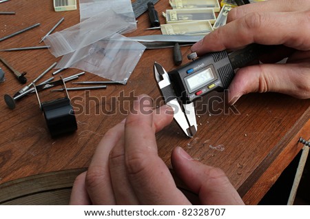 The jeweller is working at jeweller\'s workshop