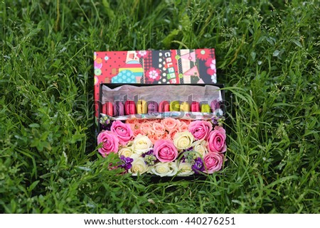 gift box with flowers with cake macaroon on the grass