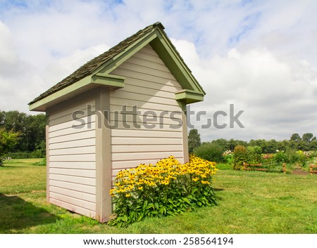 Side of a garden shed with blooming Black-Eyed Susans
