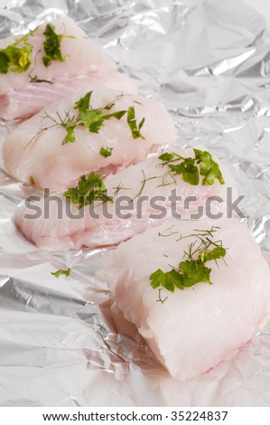 Raw monk fish with herbs on tin foil