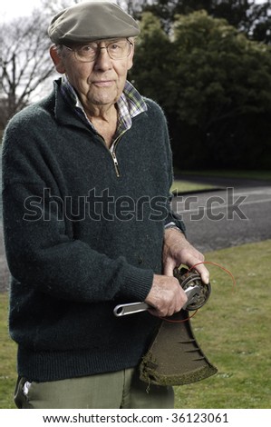 senior man fixing lawn trimmer