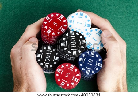 Hands collecting a big pile of poker chips