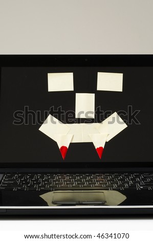 computer with post it notes in the shape of a face with horns