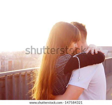 A loving young couple embracing on the bridge