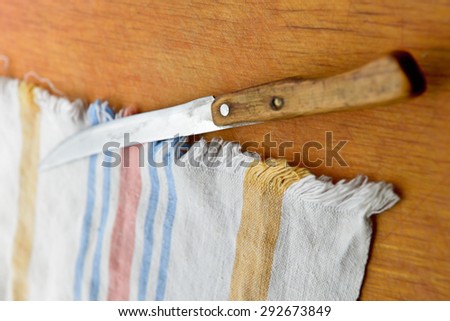 old kitchen towel and old knife on wooden background