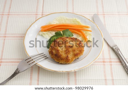 Chop chicken with carrot sticks and lettuce on a plate