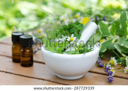 natural therapy with herbs in the mortar and essential oils