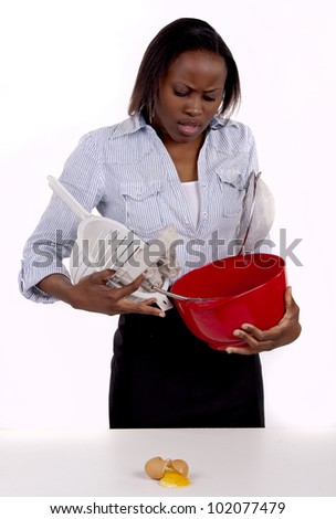 South African woman struggling with a mess she made in the kitchen.