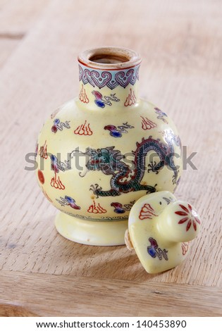 Traditional Chinese porcelain sauce bottle on wood background.
