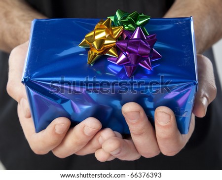 Hands holding out a wrapped gift with both hands.