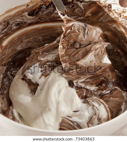 Cream being folded into chocolate cake mix