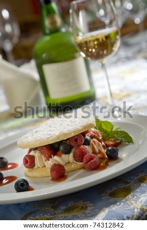 Heart shaped short-bread, with wild berry filling on a white plate, paired with a sweet dessert wine.