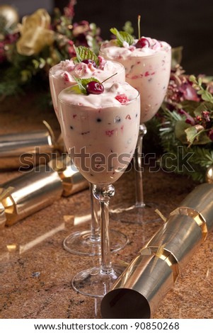 Christmas dessert with a golden cracker and decorations in the background.