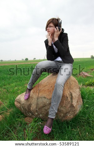 young girl sitting on a rock