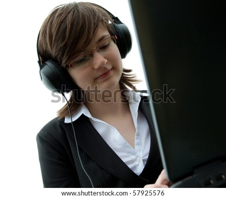 young girl with computer listening to music by headphones