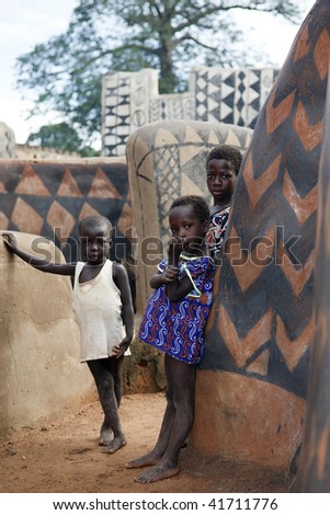 BURKINA FASO - AUG 10: gourounsi children are watching us on the visit of the village,are built with high walls to protect themselves from rival  attacks, August 10, 2009 at Tiebele, Burkina Faso