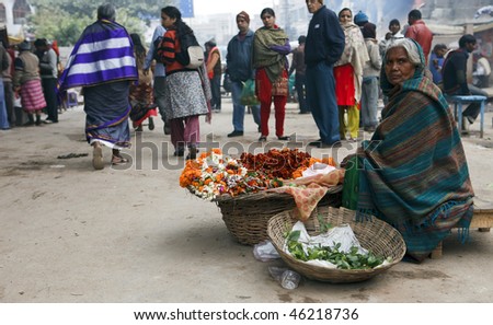VARANASI, INDIA - JANUARY 2: A woman sells flowers January 2, 2010 in Varanasi, India. The flowers are used daily in the ceremonies and offerings to the Ganges River.