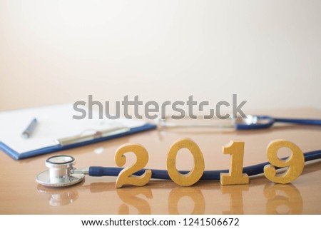 Stethoscope w/ 2019 gold wood number on doctor desk. Happy New Year for healthcare and medical. Creative idea for new trend in medicine treatment and diagnosis concept. Copy space.