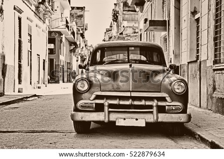 Front view of vintage classic american car parked in a street of Old Havana, Cuba - Sepia toned