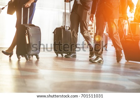 Close up of businessman team carrying suitcase while walking through a passenger boarding bridge.people and traveling luggage walking in airport terminal building