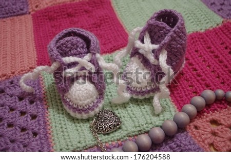 nice baby\'s bootees on crochet blanket