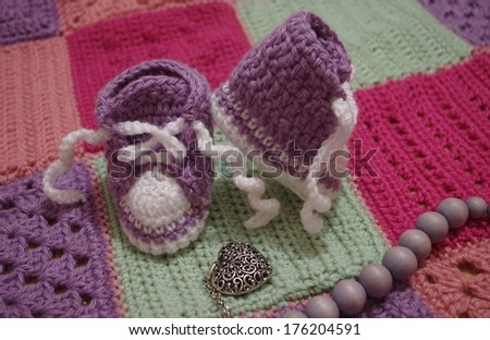 nice baby\'s bootees on crochet blanket