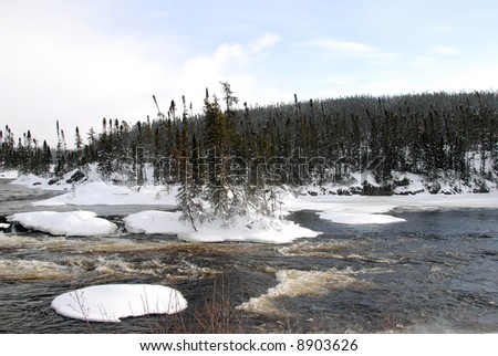 A northern river surrounded by snow on a cold day