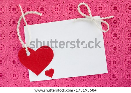 A blank white note card on pink background