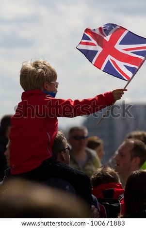 LONDON, UK - APR. 22: A boy waves a union jack flag as tens of thousands of people pass Tower Bridge during the London Marathon on the Apr 22, 2012 in London, UK