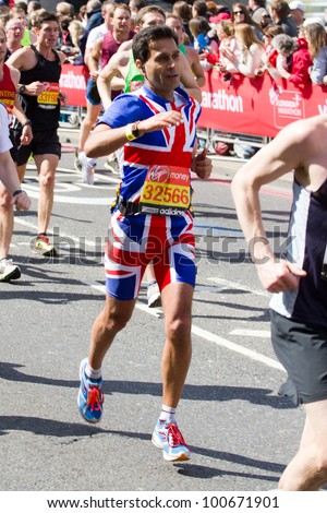 LONDON, UK - APR. 22: A man dressed in a flag costume as tens of thousands of people pass Tower Bridge during the London Marathon on the Apr 22, 2012 in London, UK