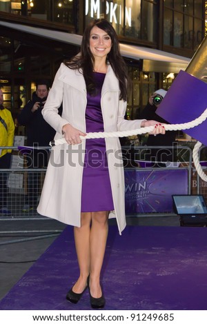 LONDON UK - DECEMBER 20: Christine Bleaky launches a giant party popper containing Olympic 2012 tickets on unsuspecting shoppers in East Londons Westfield  on the December 20, 2011 in London, UK
