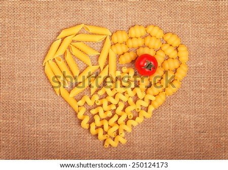 heart of pasta on a fabric background with tomato