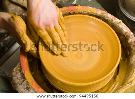 hands of a potter, creating an earthen jar of white clay