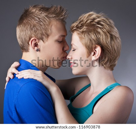 Happy couple of young people having fun together against black background