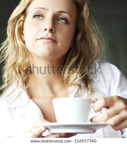 Portrait of beautiful woman, sitting in a cafe outdoor, drinking coffee