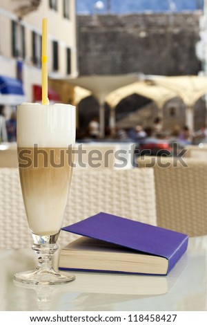 Breakfast latte. Purple book on the table