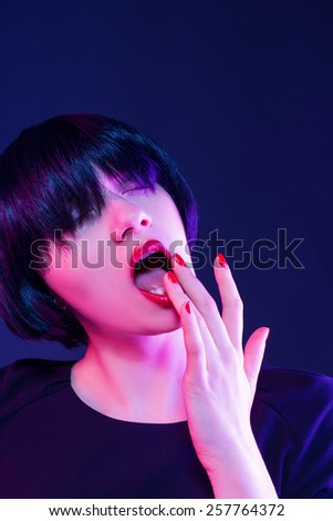 Closeup portrait of a sexy brunette with finger in mouth