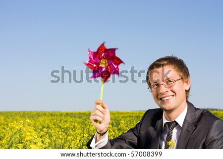 Well-dressed young businessman is resting in a field