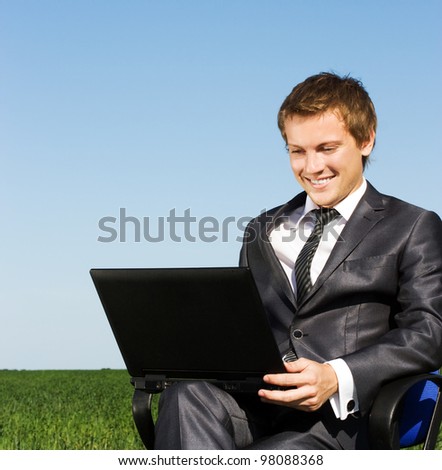 Businessman in the field, with a laptop. Happy, successful