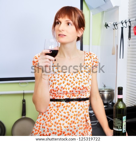 young woman drink wine and relax at kitchen