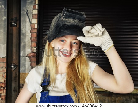 beautiful smiling blond woman in welder helmet