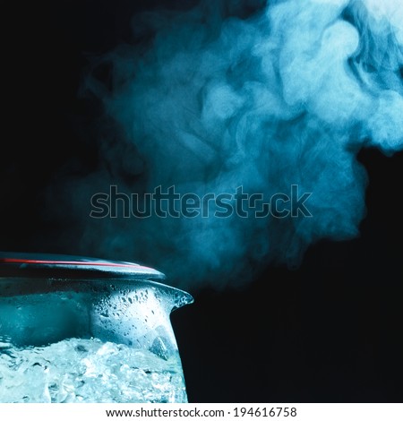 tea kettle with boiling water, dark background