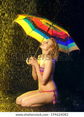 happy beautiful girl with umbrella under rain, black background